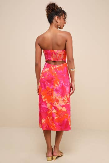 model successful  a strapless floral formal  with cutout backmost  and golden  sandals, showcasing a stylish summertime  outfit