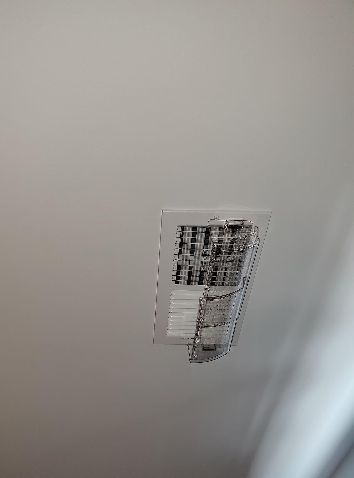 Ceiling aerial  vent with a transparent integrative  deflector attached, directing airflow