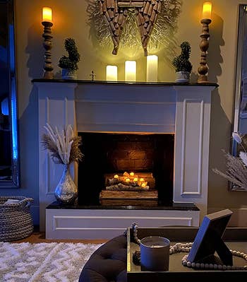 reviewer photo of the tealight candle holder filled with lit candles in a fireplace
