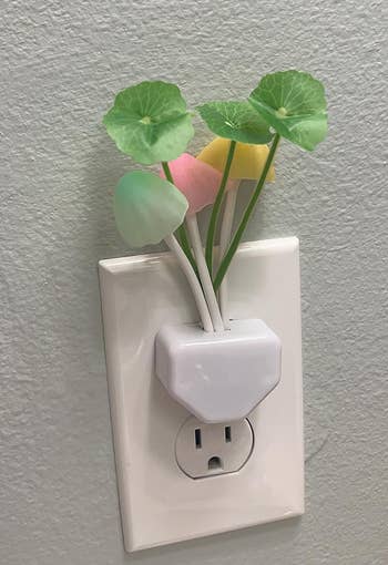 reviewer's mushroom nightlight  plugged into an outlet