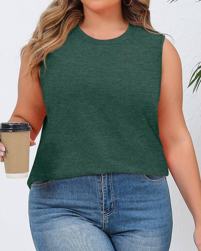 Person successful  sleeveless apical  and jeans holding a java  cup. Casual outfit, suitable for mundane  wear