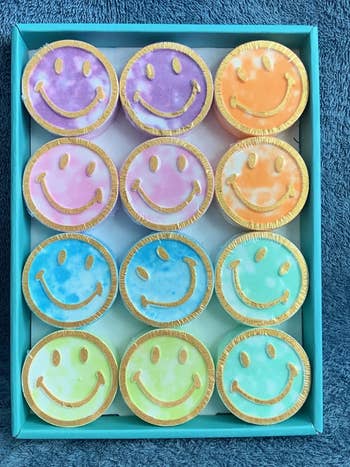 Box with an assortment of smiley face cookies in different pastel shades. Perfect for a cheerful gift