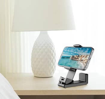 The black phone mount on a nightstand holding a phone