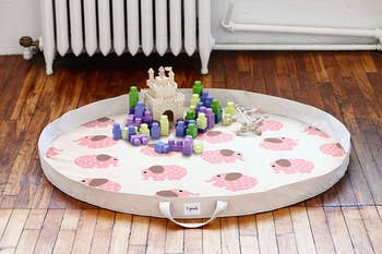the elephant-printed play mat open with toys in it