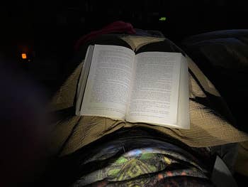 a reviewer using a reading light around their neck to illuminate their pages