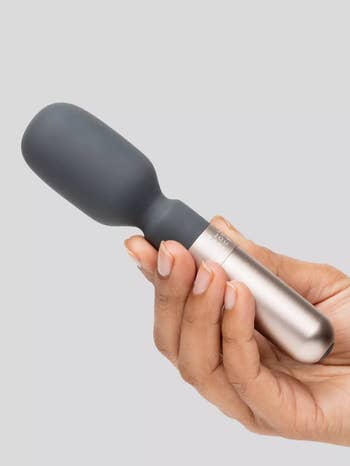 Model holding chrome and gray mini wand vibrator
