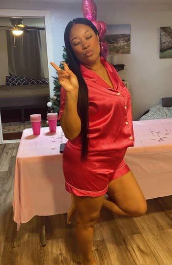 Woman successful silk pajamas poses playfully with a bid motion astatine a casual indoor gathering