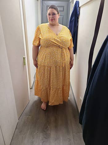 Reviewer wearing the maxi dress in yellow with a white floral design