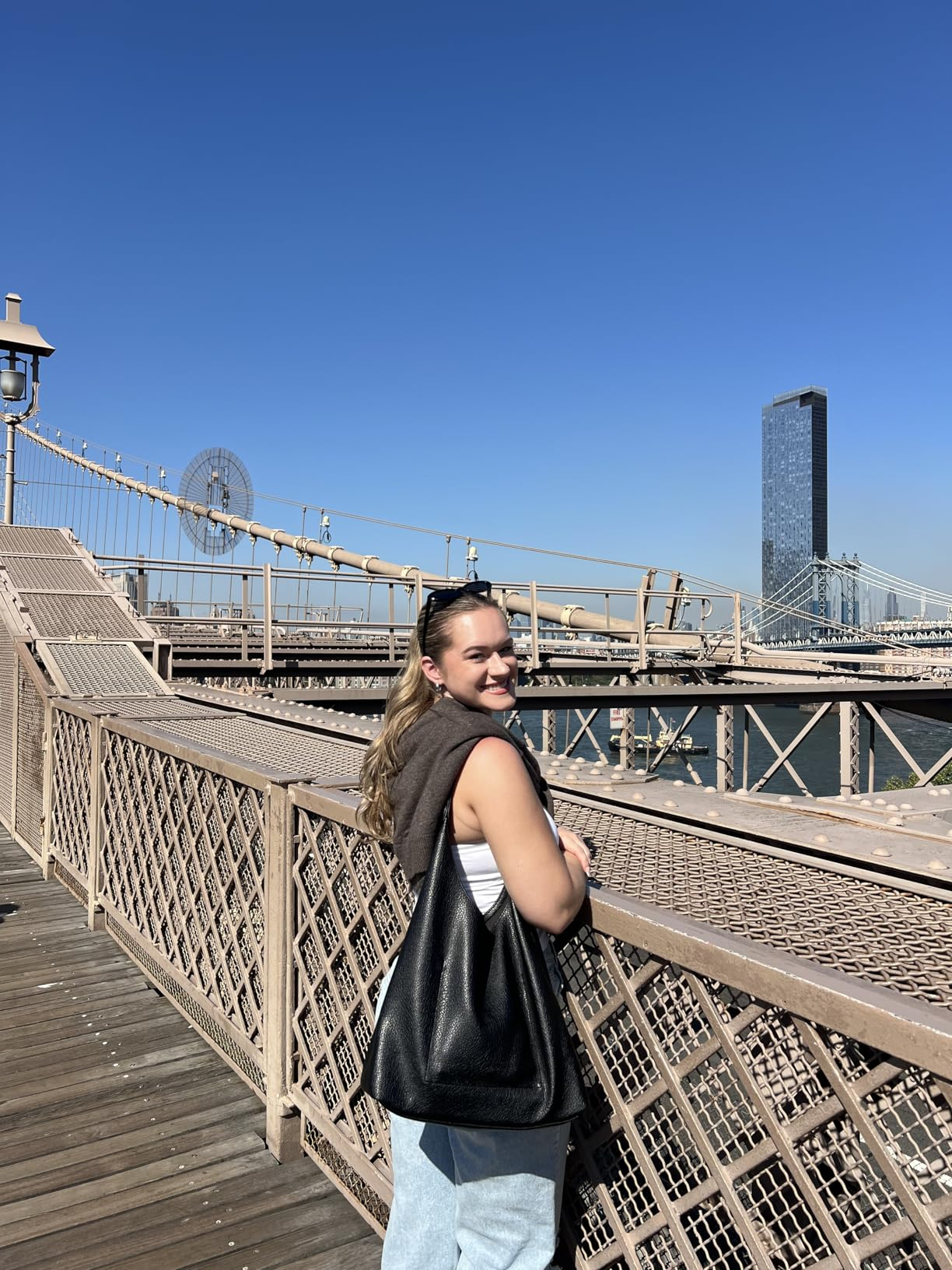 reviewer smiling and posing connected  a span  with the tote successful  achromatic  slung connected  their shoulder