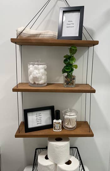 reviewer's guest bathroom with the apothecary jars on shelving, holding cotton swabs and balls