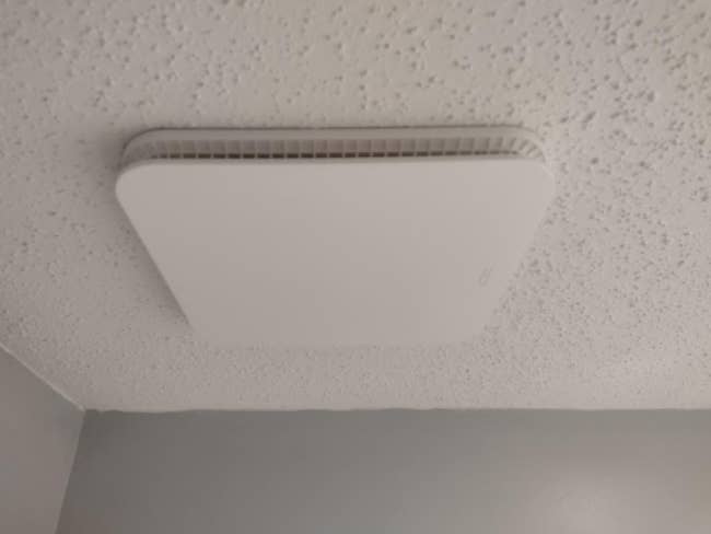 Square aerial vent installed connected a textured ceiling