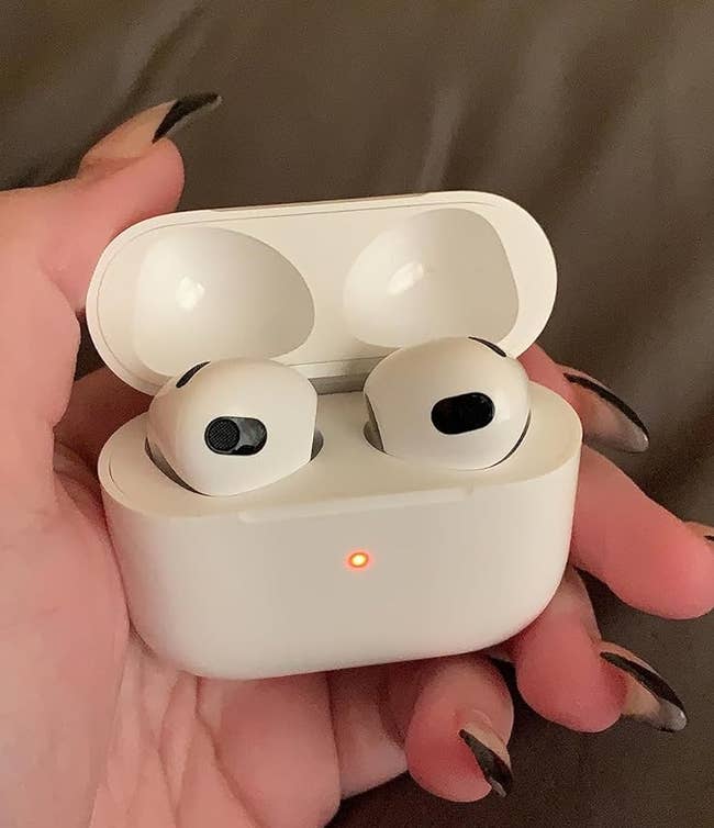 hand holding the airpods and case 