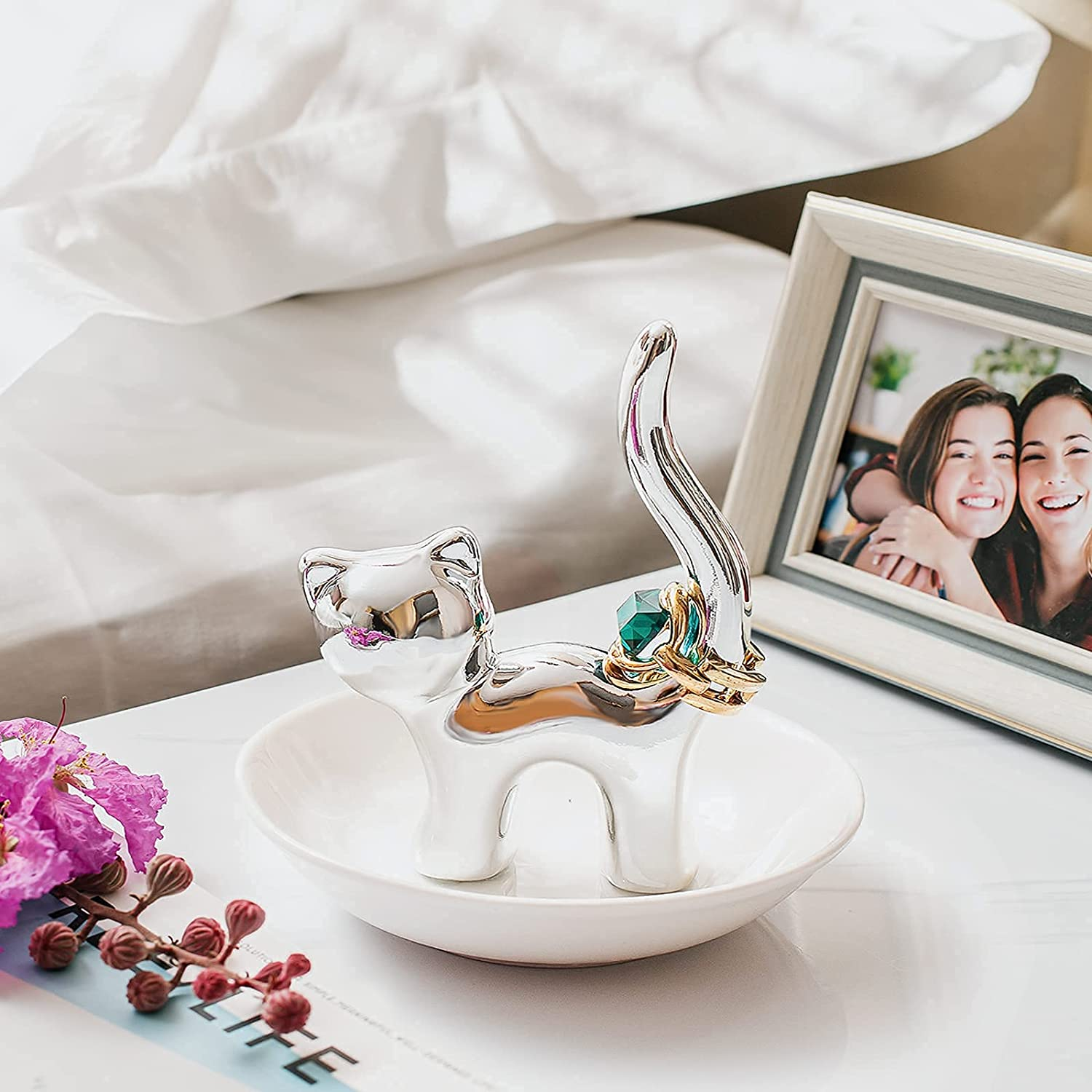 the silver cat trinket dish holding a ring on the tail