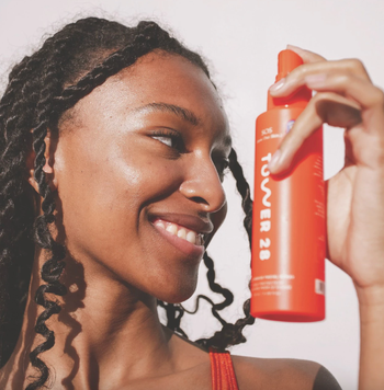 a model holding the tower28 spray bottle