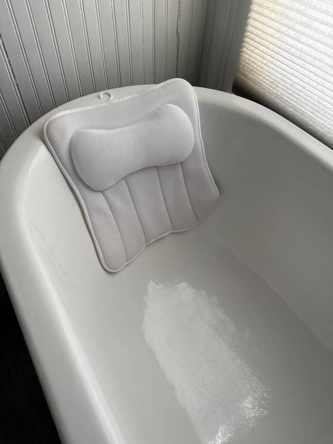 Bathtub with a cushioned pillow attached to the backrest for added comfortableness and support