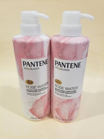 Reviewer image of pink and white shampoo and conditioner bottle with pumps on white counter