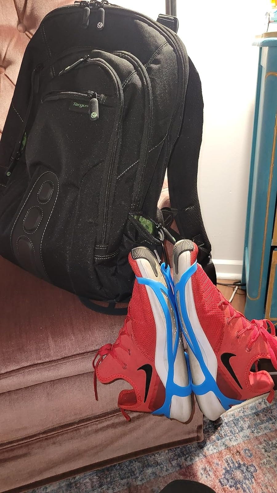 Backpack with a pair of red sneakers hanging from it with the shoe holsters