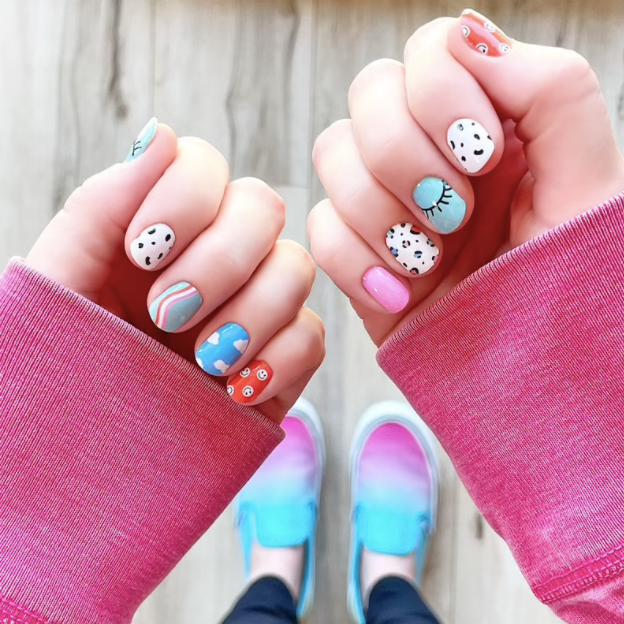model in nail stickers with different complementary designs — animal prints, clouds, red with smiley faces, solid pink, mint with an eyelash graphic, and mint with a pink squiggle