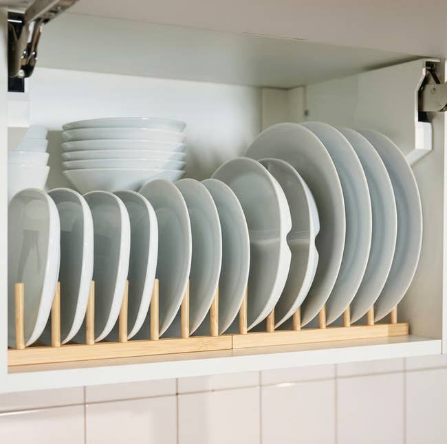 Plates and bowls organized successful  a woody  crockery  rack wrong  a cupboard
