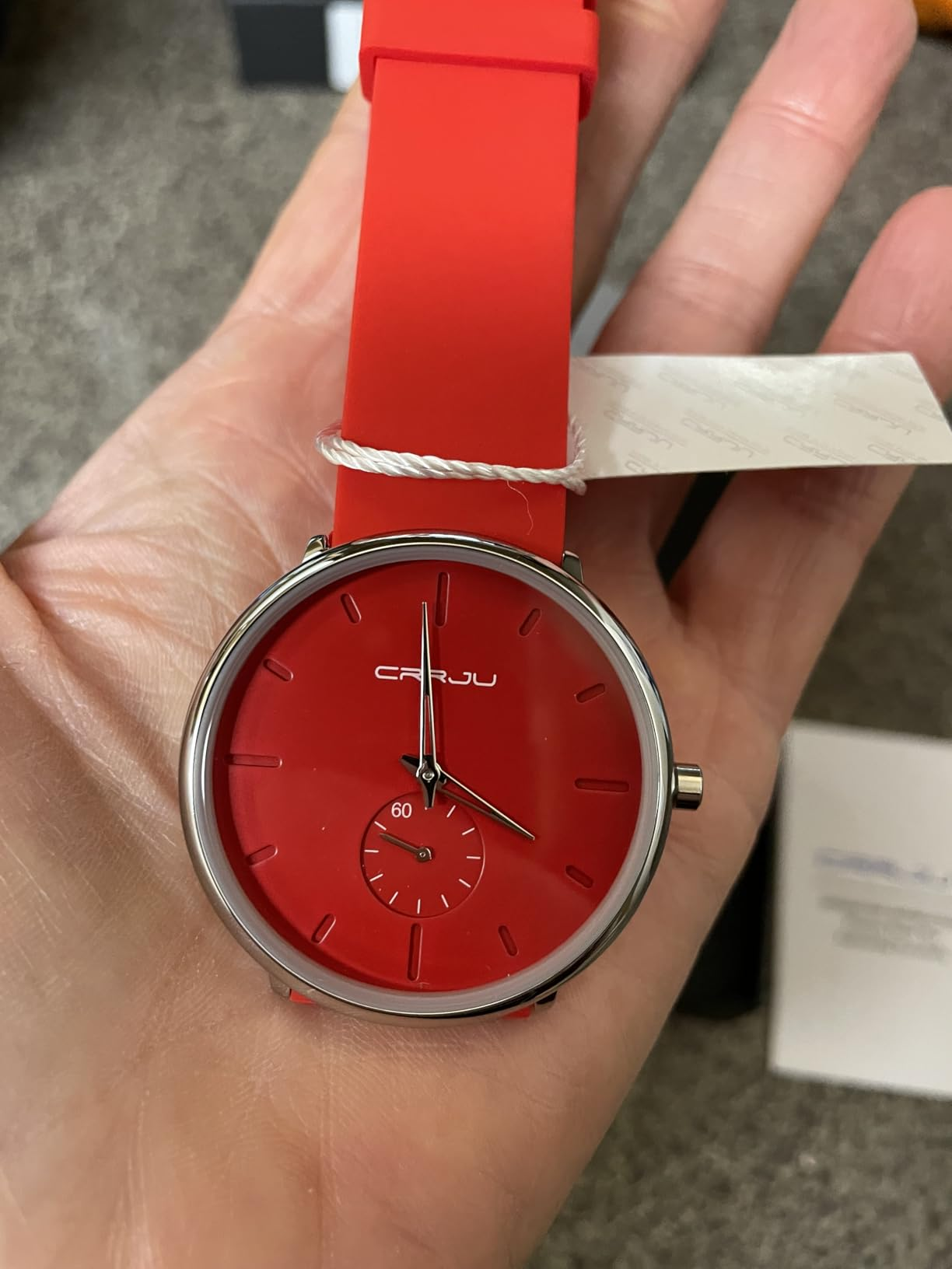reviewer holding the reddish  watch
