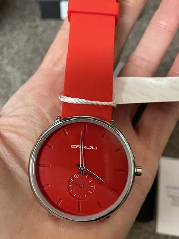 reviewer holding the reddish watch