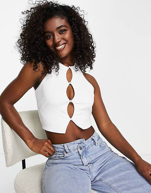 Model in white crop top with several keyhole cutouts down the front
