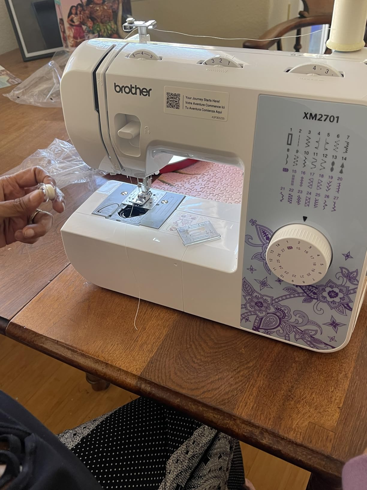 sewing instrumentality   connected  a woody  array  with reviewer's manus  holding a bobbin with achromatic  thread