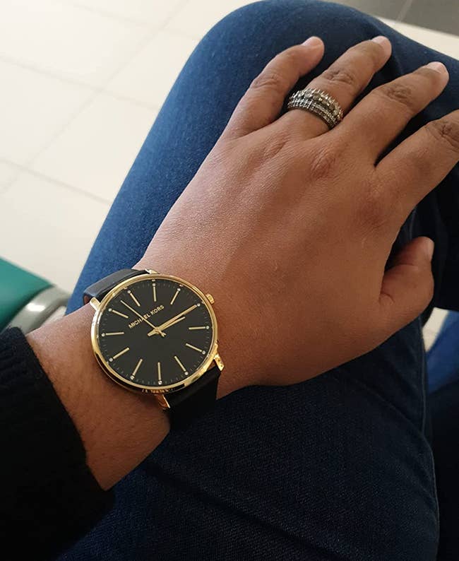 Reviewer photo of the black leather watch with gold face