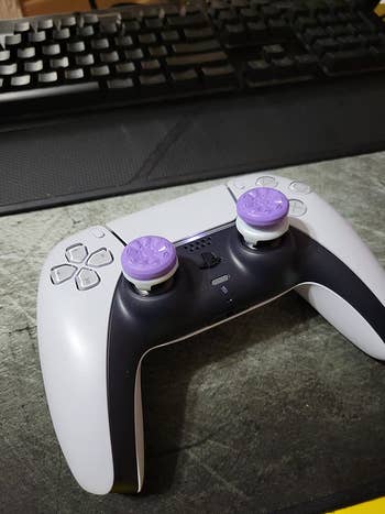 a reviewer's controller with the purple grips on it