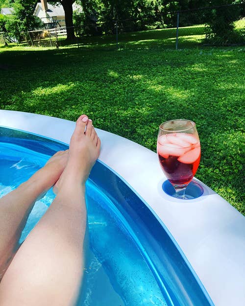 reviewer in the pool with glass of drink in cup holder