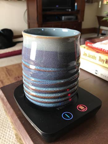 reviewer's ceramic mug on the black warming device