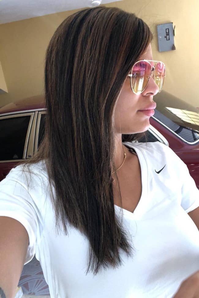 Person with long, consecutive  hairsbreadth  wearing stylish sunglasses and a achromatic  shirt, lasting  successful  beforehand   of a car