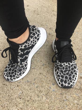 a reviewer wearing the black leopard print shoes