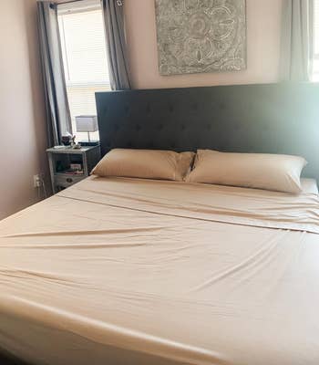 A neatly made furniture  with ivory sheets 