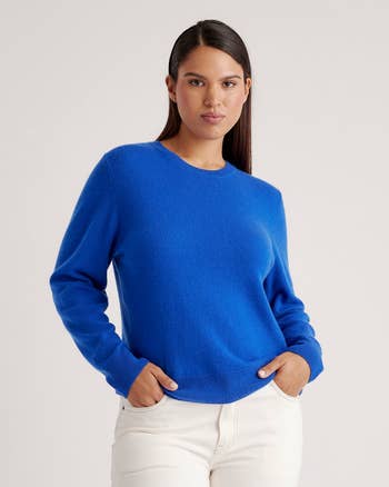 model wearing a crewneck sweater paired with white pants