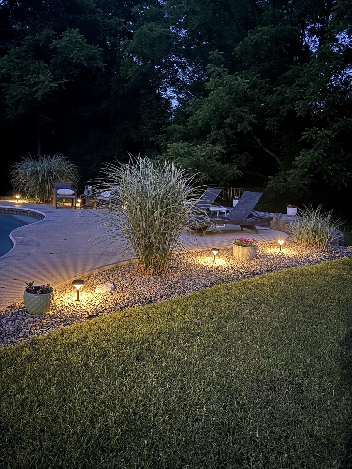 Outdoor patio by a pool with garden lights