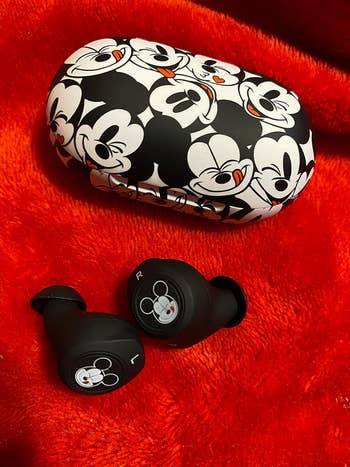 a reviewer's black and white earbud case with a mickey print on it