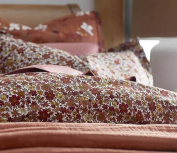 rust multi leaf patterned bed sheets on bed