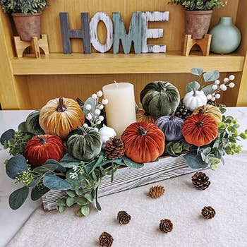 photo of the pumpkins in rustic fall color decorated around a centerpiece with candle in the middle