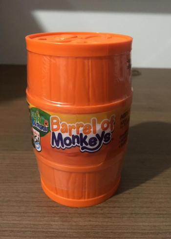 Reviewer image of plastic orange barrel-shaped container that reads 