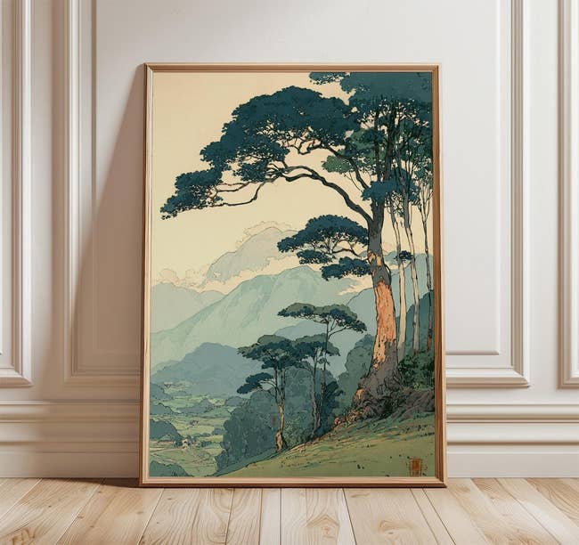 Framed scenery  artwork depicting a stylized upland  country   with trees, displayed successful  a minimalist room