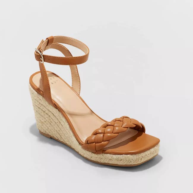 A wedge-heel with a braided front wrap and ankle buckle in the shade brown