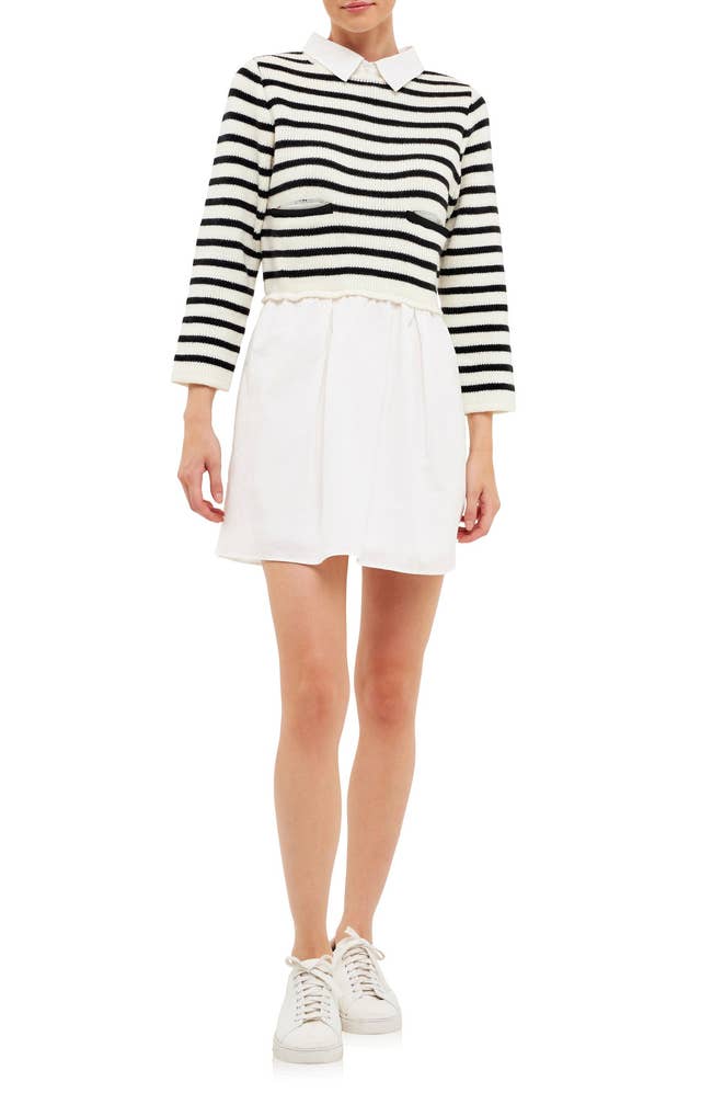 model in white mini shirt dress with black and white stripe sweater bodice worn with white sneakers
