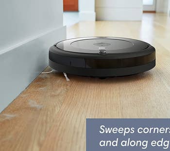 the roomba cleaning up floor dust against a wall with its bristles