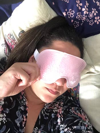 Reviewer laying down while wearing the pink eye mask