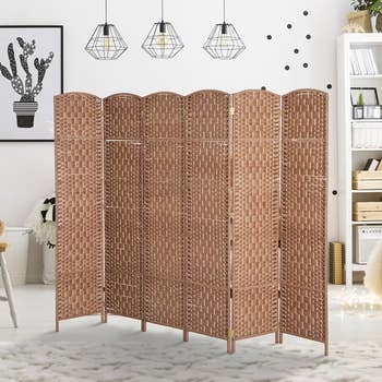 Room divider with woven plan successful a modern surviving space, featuring shelves and pendant lights