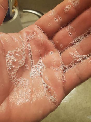 A person's open hand with soap bubbles on it
