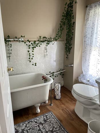 reviewer photo of the fake vine garland hanging from their bathroom walls