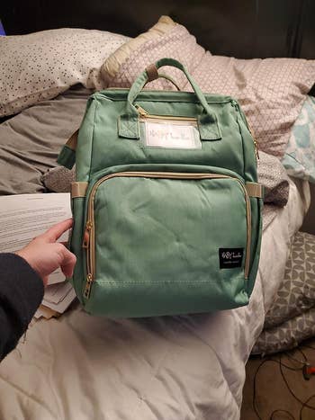reviewer showing the diaper bag in teal