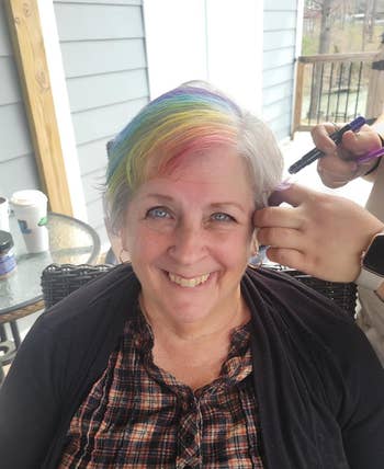 Smiling pistillate   with rainbow-colored hairsbreadth  being styled outdoors